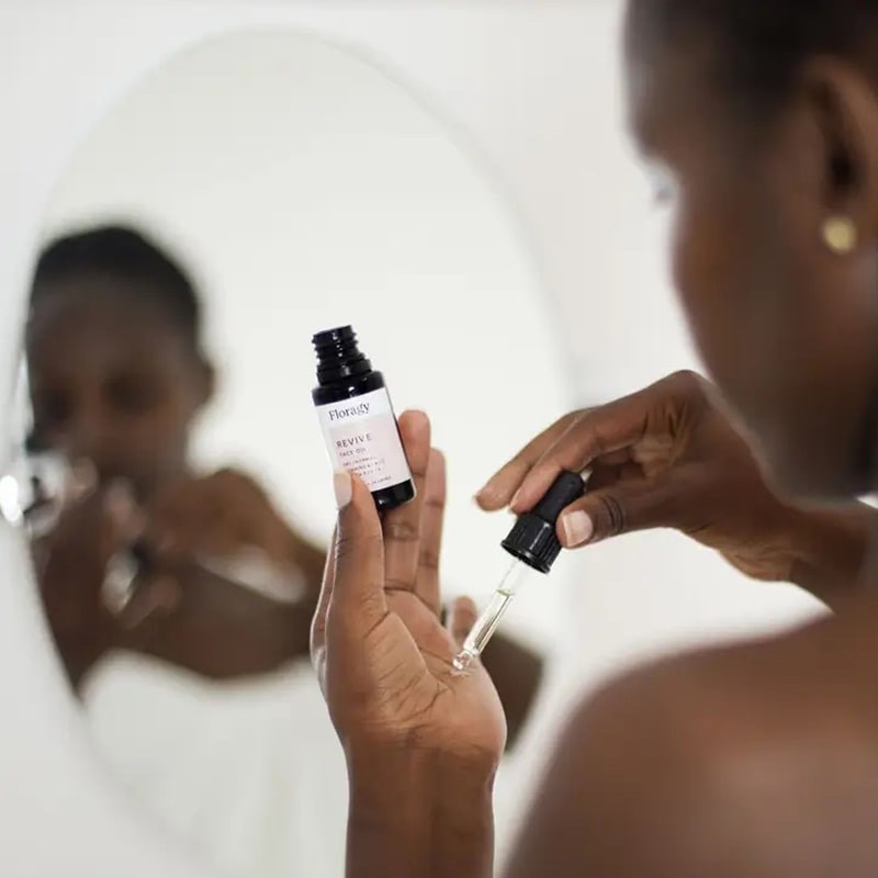 Floragy Revive – Face Oil - Model shown dispensing product into hand