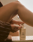 Salt & Stone Bergamot & Hinoki Body Lotion - Model shown dispensing product into hand