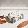 Formulary 55 Bourbon & Vanilla Bath Bar - packaged bar of soap with dried leaves in the foreground