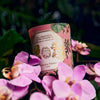 Carriere Freres Geranium Candle - Lifestyle photo of candle in a bed of flowers
