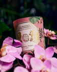 Carriere Freres Geranium Candle - Lifestyle photo of candle in a bed of flowers