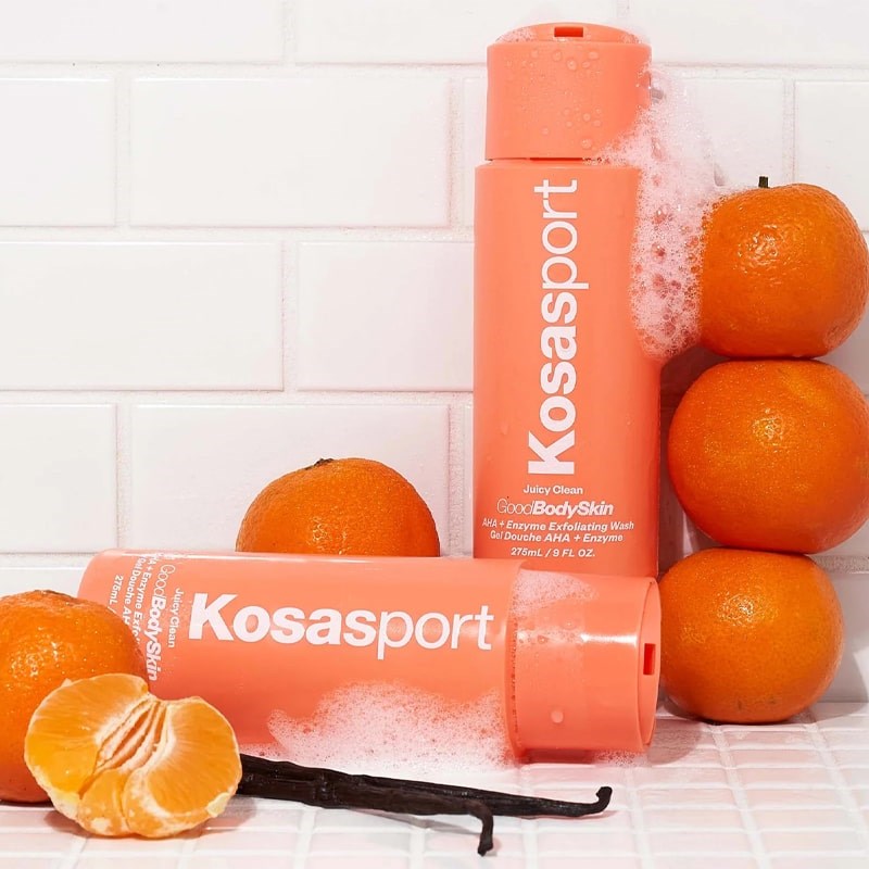 Kosas Good Body Skin Body Wash - Lifestyle shot of Body wash bottles in shower with vanilla beans and oranges
