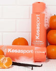 Kosas Good Body Skin Body Wash - Lifestyle shot of Body wash bottles in shower with vanilla beans and oranges