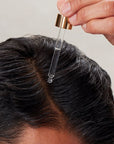 Innersense Organic Beauty Hair Renew Daily Active Serum - Model holding dropper close to scalp
