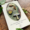 Georgiou Draws Woodland Seeds Mini Enamel Pin Badge Set - Product shown on wood table