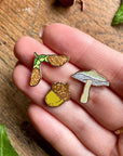 Georgiou Draws Woodland Seeds Mini Enamel Pin Badge Set- Product shown in models hand