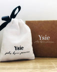 YSIE Angelique Mother-Of-Pearl Gold Plated Earrings - Product bag shown next to logo