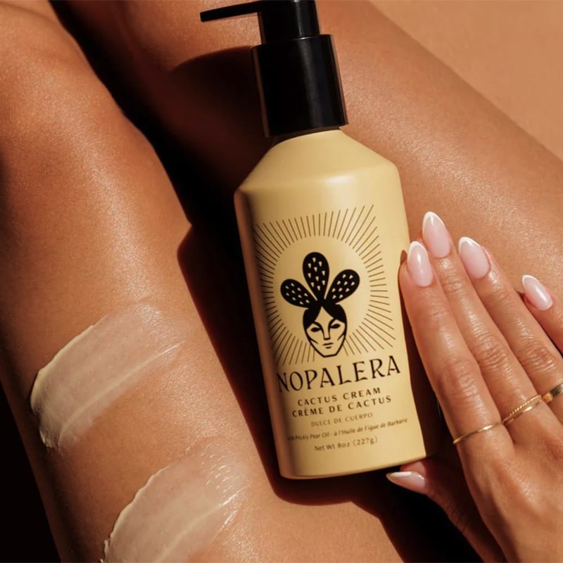 Nopalera Cactus Cream - model with lotion swatches on leg and holding bottle