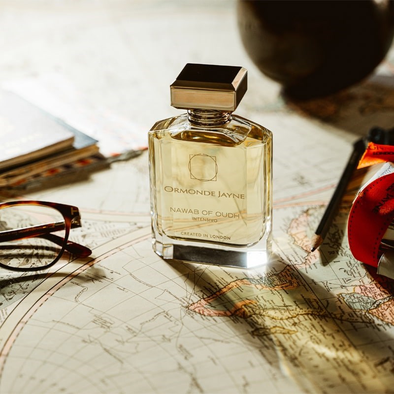Ormonde Jayne Nawab of Oudh Intensivo Eau de Parfum - lifestyle photo of perfume bottle, glasses, passports, on map