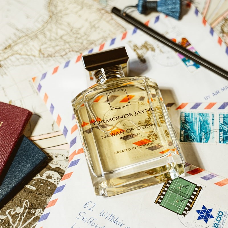 Ormonde Jayne Nawab of Oudh Intensivo Eau de Parfum - lifestyle photo of perfume bottle, glasses, passports, pen, and letters on map