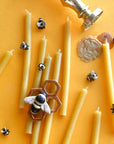 Camp Hollow Beeswax Birthday Candle Set of 10 - lifestyle image of candles, tiny bees, wax, and cake topper