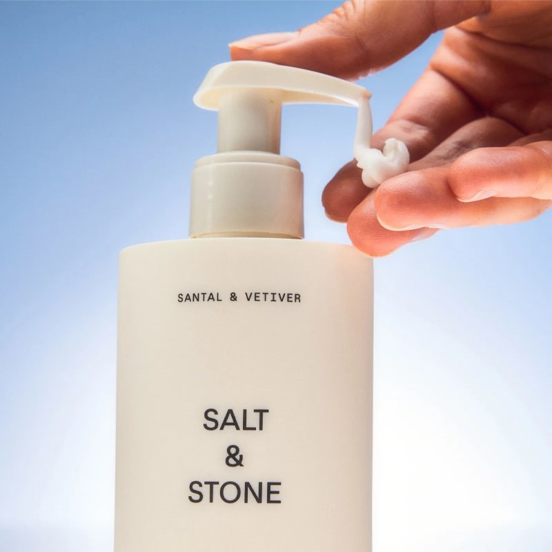 Salt &amp; Stone Santal &amp; Vetiver Body Lotion - model hand pumping lotion from bottle