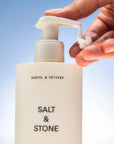 Salt & Stone Santal & Vetiver Body Lotion - model hand pumping lotion from bottle