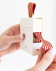 Bespoke Letterpress Red Gold Foil Striped Ribbon - Model shown holding ribbon box pulling ribbon out