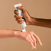 Bamford Geranium Hand Balm - Model shown dispensing product onto hand