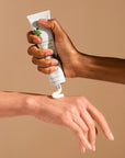 Bamford Geranium Hand Balm - Model shown dispensing product onto hand