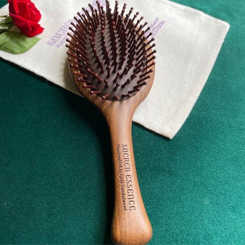 The Sacred Essence Angel Scalp Massage Brush - Product shown on teal background