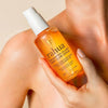 Rahua Enchanted Island Body Glow Serum - Product shown in models hand