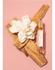 Rahua by Amazon Beauty Palo Santo Oil Perfume showing sitting on palo santo with flower