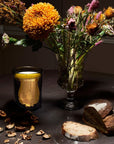 Cire Trudon Abd el Kader Candle lifestyle shot with flowers in a vase in the background