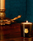 Cire Trudon Ernesto Petite Candle lifestyle shot with candle burning on wood table